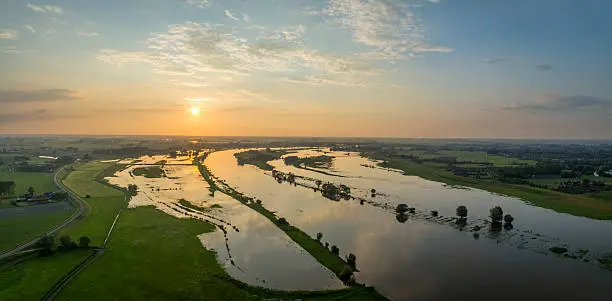 Hoogwater in het IJssellandschap bij zonsondergang